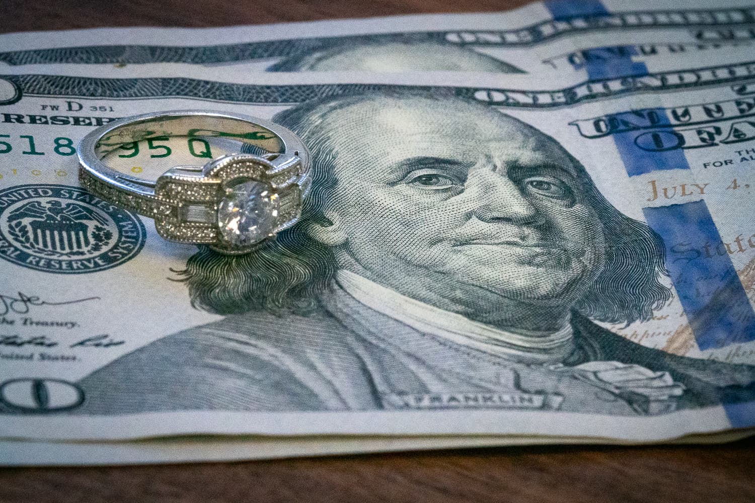 White gold diamond engagement ring on a US dollar