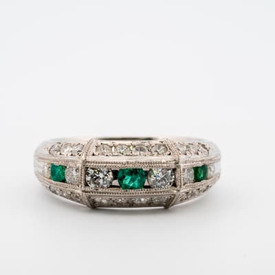 Front image of platinum ring with round emeralds and diamonds