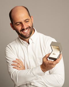 Dolgins Jewelry Store Owner Joseph Dolginow holding a gold and diamond engagement ring in a jewelry box