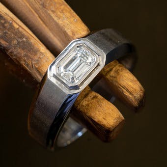 Men's emerald cut diamond wedding ring after being set and sized 
