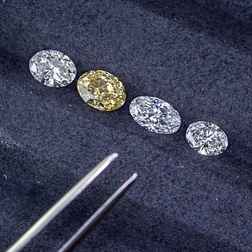 Selecting between 4 different oval shaped diamonds including a fancy canary yellow