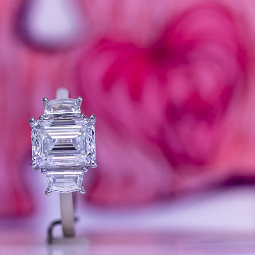 A platinum emerald cut diamond engagement ring, which also features 2 epaulette side diamonds