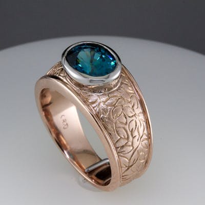 Rose gold encgraved band with 3 carat oval blue zircon - side view