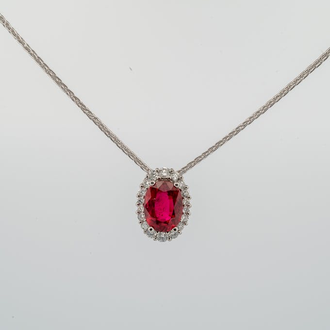 Ruby graduated halo diamond pendant in platinum front view