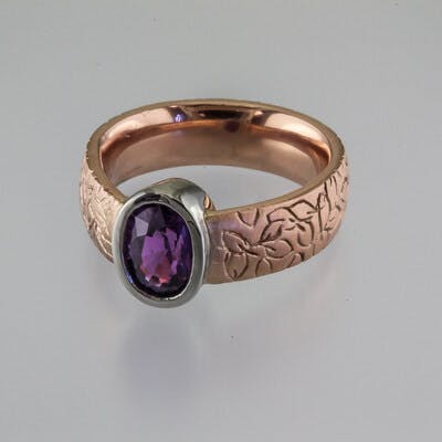 3/4 view of oval purple sapphire in rose gold ring