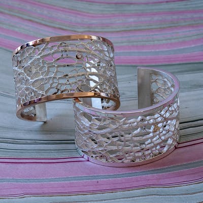 Two cactus cuff bracelets one in silver and one with rose gold