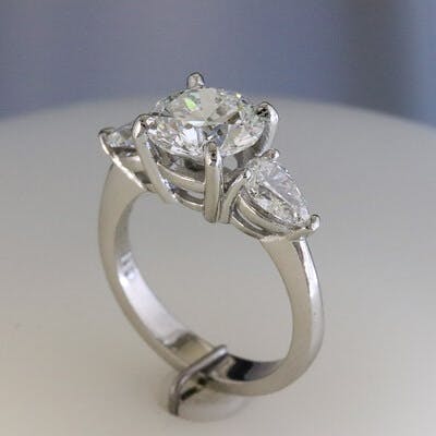 Side view of platinum and round 3 diamond ring 